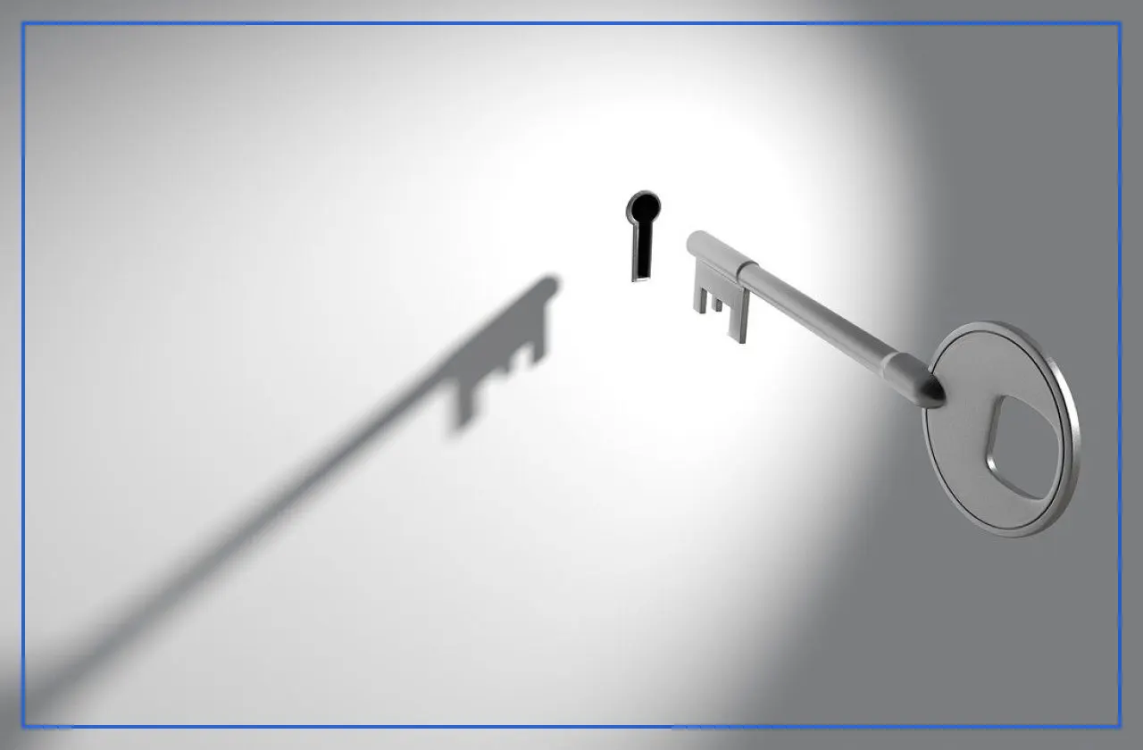 A key moving toward a keyhole on a white wall
