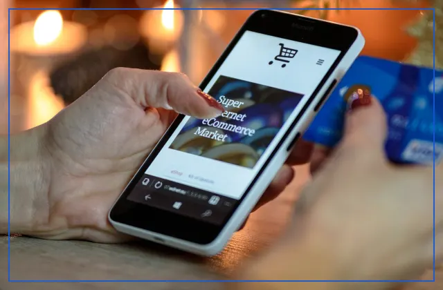 Shopper browsing an online store on a smartphone while holding a bank card