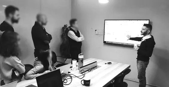 A QPSoftware team meeting around a screen