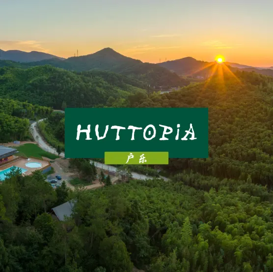 The Huttopia logo over a forest at sunrise