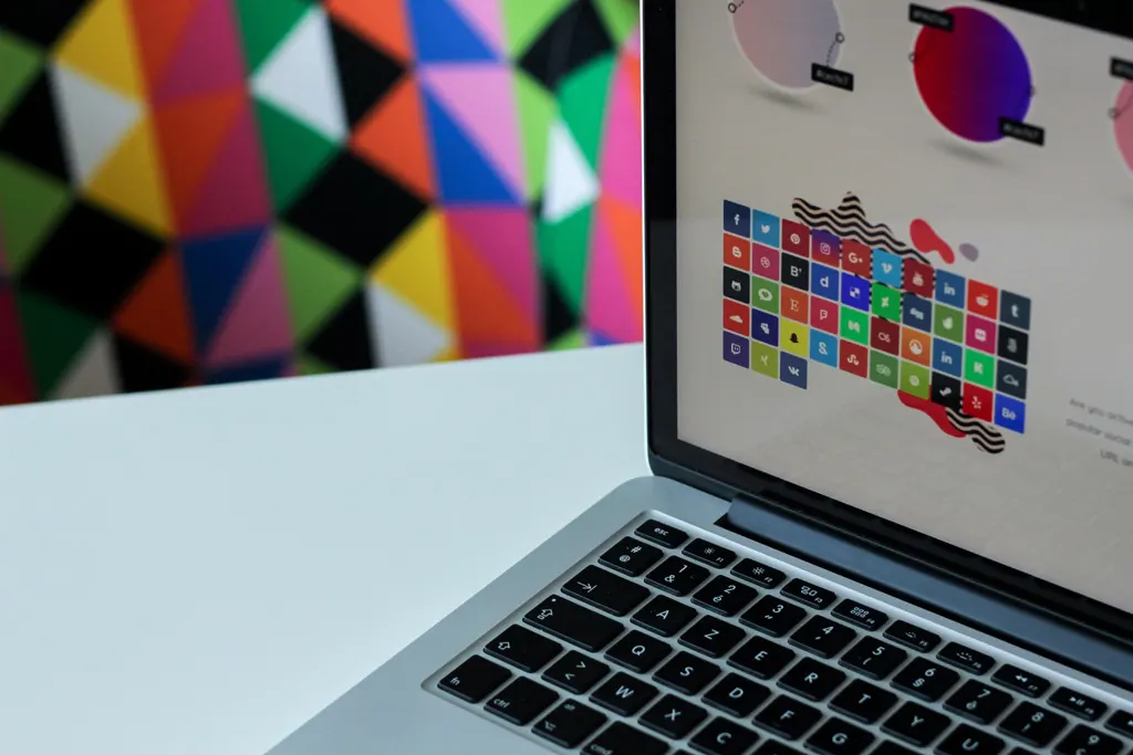 Laptop showing a web design page with a grid of colorful social media icons