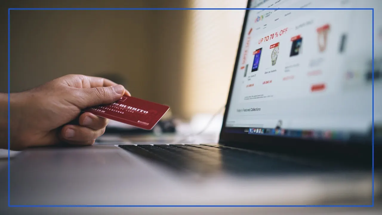 Customer is holding a credit card and browsing an ecommerce website