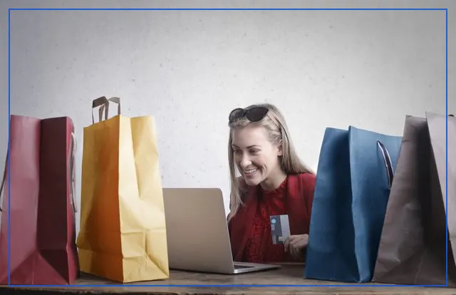 A shopper browsing an online store at home, surrounded by shopping bags